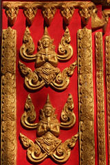 Obraz premium Golden painted buddha images on red background on a building of a temple site in Siamese Lao PDR, Southeast Asia