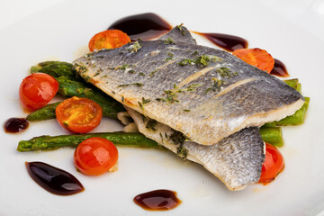 A plate of fish and vegetable tomato with asparagus