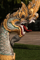 Ornamental dragon head as entrance decoration to a praying hall of a wat building in Siamese Lao...