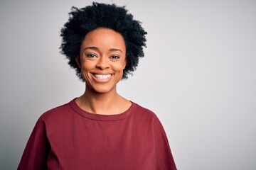 Young beautiful African American afro woman with curly hair wearing casual t-shirt standing with a happy and cool smile on face. Lucky person.