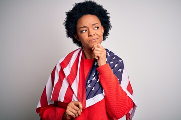 Young African American afro woman with curly hair wearing united states of america flag serious face thinking about question, very confused idea