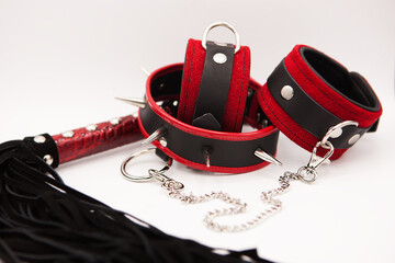 Sexy toys. Leather whip, collar with spikes and handcuffs isolated on white background	