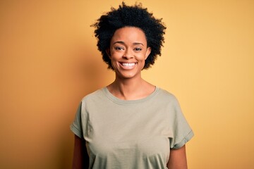 Obraz na płótnie Canvas Young beautiful African American afro woman with curly hair wearing casual t-shirt with a happy and cool smile on face. Lucky person.
