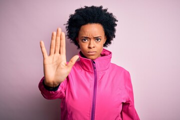 Young African American afro sportswoman with curly hair wearing sportswear doin sport doing stop...