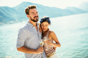 Young couple with wine having romantic date on the beach