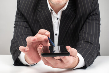 Businessman shows screen of a smartphone. Man in a suit shows ph