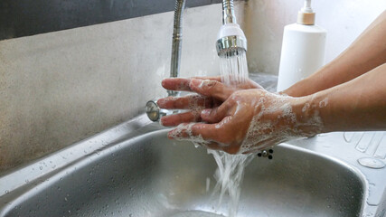 Close up washing hands with bubble purify soap and water.