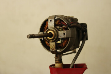 The electric motor of the old fan that has been removed for repair
