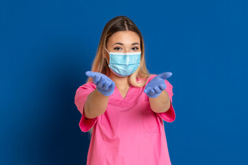 Fototapeta na wymiar Young doctor wearing a mask face and a pink uniform
