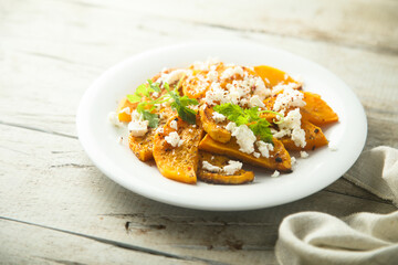 Roasted pumpkin with spices and fresh cheese