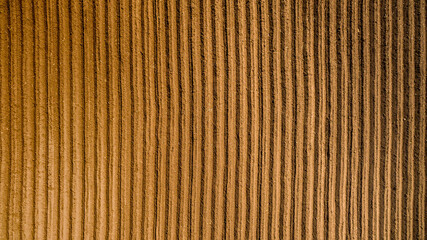 Aerial view ; Rows of soil before planting. Furrows row pattern in a plowed field prepared for planting crops in spring. Aerial view of land prepared for planting and cultivating the crop.