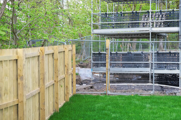 Garden fence made of wood planks across new build house