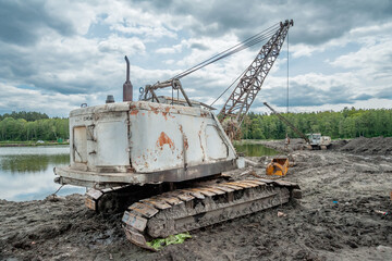 Fototapeta na wymiar Excavator on a dirt road near a lake.