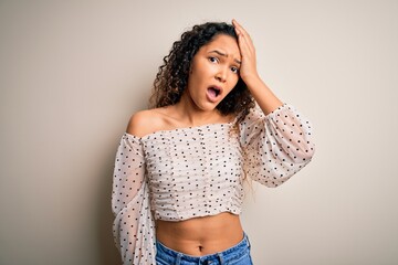 Young beautiful woman with curly hair wearing casual t-shirt standing over white background...