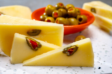 Cheese collection, fresh Italian pecorino cheese made from sheep milk filled with green olives stuffed with red paprika