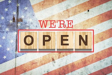 We are open. The inscription on wooden blocks on the background of the flag of America. Business.