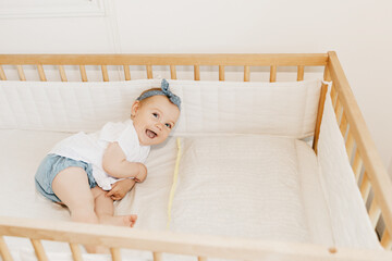 baby girl in her bed, with headband. 