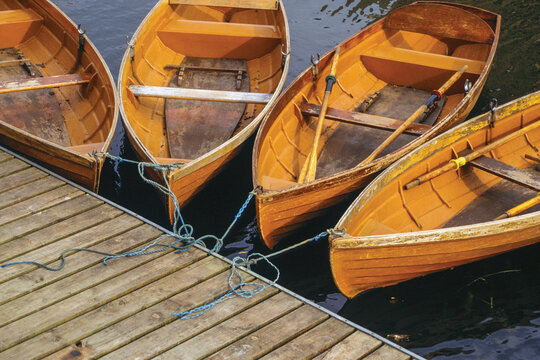 Several wooden boats tied up on a pier by the Cam River in Cambridge. A beautiful and peaceful university town in eastern England.