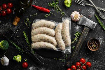 Raw sausages from turkey meat in vacuum packing. Top view. On a black background.
