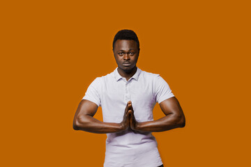 Relaxed black man closes eyes and does yoga. Calm and pacification of a african man. Public...