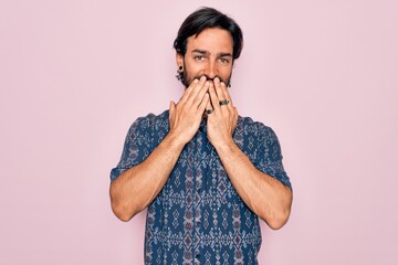 Young handsome hispanic bohemian man wearing hippie style over pink background laughing and...