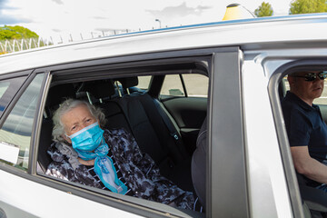 Transportation of an elderly woman in a taxi. White-haired +80 grandmother in a medical mask.
Coronavirus Protection