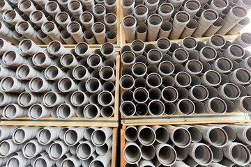 Gray plastic pipes lie in rows