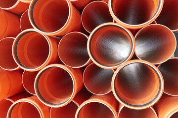 Orange plastic pipes lie in rows