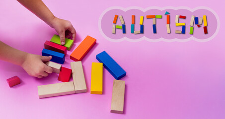 A child with an autism spectrum disorder builds a house from a wooden constructor. Concept of autism.