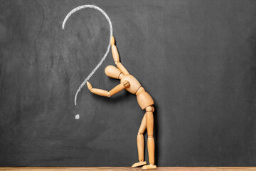 wooden man and question mark on chalkboard background