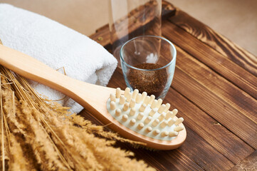 Brush, washcloth for body massage and skin cleaning with natural coffee scrub on beige background. Spa.