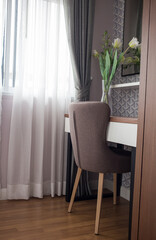 Desk chair in the bedroom with white curtains in the morning light
