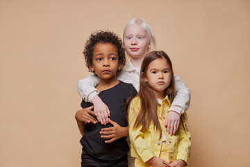 portrait of adorable diverse children isolated. afro american, albino and european children stand together, close friendship between them. people diversity, children, natural beauty concept