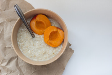 bowl with flakes and apricot on a white background