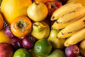 Fruit basket. Apple, lemon, mango, plum., melon, banana, pear and persimmon