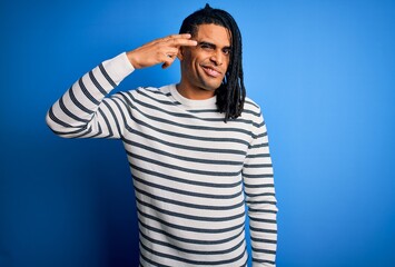 Young handsome african american afro man with dreadlocks wearing casual striped sweater Shooting and killing oneself pointing hand and fingers to head like gun, suicide gesture.