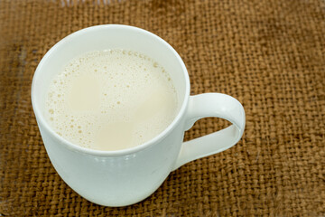 Bottle of milk and glass of milk on a wooden table on a blue background