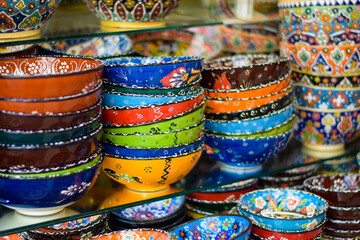 Fototapeta na wymiar Colorful Glass bowls and saucers kept on display as a souvenir. These artistic hand made designer bowls are used as home decor items