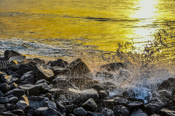Sea Waves splashing on black rocks on a sea shore. Relaxing view for tourists visiting any sea or ocean