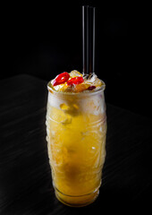 cocktail mango chili in glass on black wooden table background