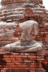 Old Buddha statue without head in the midst of ruins of the Chaiwatthanaram Temple Ayutthaya, Thailand.