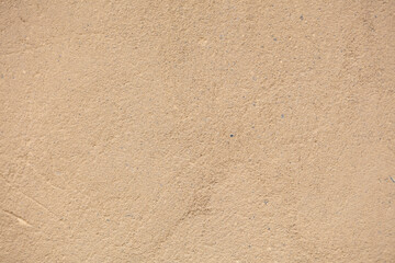 Beige concrete texture with potholes and scratches closeup.