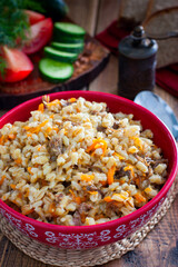 Barley porridge with stewed beef in a ceramic bowl, selective focus