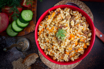 Barley porridge with stewed beef in a ceramic bowl, selective focus