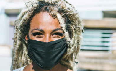 Portrait of african girl with blond dreadlocks wearing face protective mask for Coronavirus...