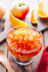 Fruit jam from apples and oranges in a glass vase, selective focus