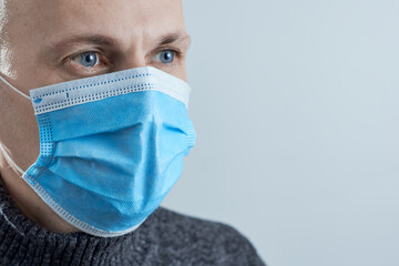 Man wearing a protective mask on gray background. Photo with copy space.