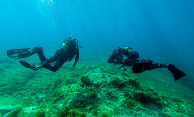Scuba divers, diving in the mediterranean sea.