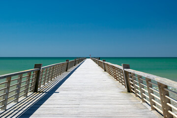 Fototapeta premium view of the pier of saint jean de monts in magnificent weather, the emerald green ocean on the horizon, vendée, france.