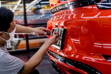 Technician changing car plate number in service center.